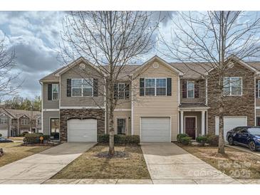 Townhome exterior featuring neutral siding, stone accents, attached garages, and tidy landscaping at 9035 Bradstreet Commons Way, Charlotte, NC 28215