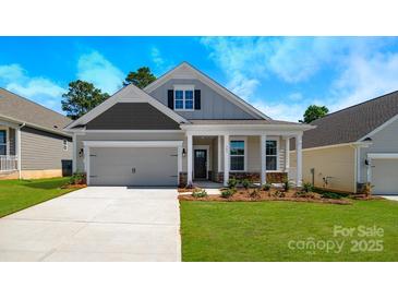 Charming one-story home featuring a covered front porch, two-car garage, and manicured lawn at 115 S Shayna Rd, Troutman, NC 28166