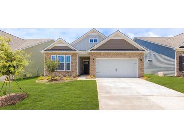 Charming single-story home boasts stone accents, a two-car garage, and a well-manicured lawn at 120 S Shayna Rd, Troutman, NC 28166