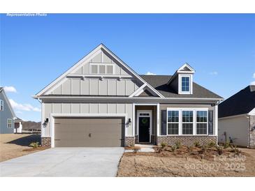 Charming single-story home showcasing a gray color scheme, a two-car garage, and a welcoming front entrance at 122 N Shayna Rd, Troutman, NC 28166
