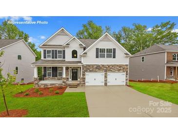 Charming two-story home boasts stone accents, a covered porch, and a convenient two-car garage at 130 Fordingbridge Ln, Mooresville, NC 28115