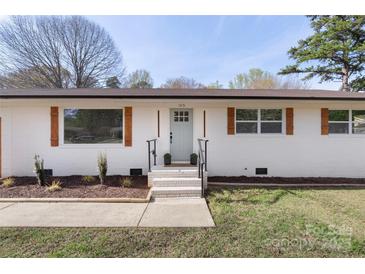 Charming single-story home with a white brick exterior, updated windows, and a well-manicured lawn at 1315 Vickie Ln, Matthews, NC 28104