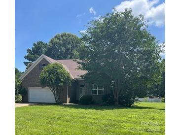 Traditional brick home with an attached garage, manicured lawn, and mature trees providing shade at 201 Fancy Lady Ct, York, SC 29745