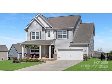 Charming two-story home with light gray siding, white trim, and an attached two-car garage in a desirable neighborhood at 3013 Whipcord Dr, Waxhaw, NC 28173