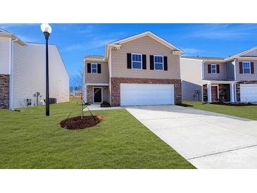 Charming two-story home with tan siding, brick accents, an attached two-car garage, and a well-manicured lawn at 3040 Ora Smith Rd, Lincolnton, NC 28092