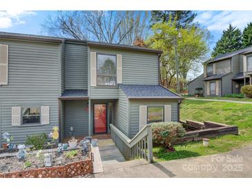 Charming gray two-story townhouse featuring a small garden, wood stairs, and a red front door at 4340 N Center Ne St # 508, Hickory, NC 28601