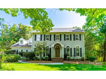 Charming two-story home with a manicured lawn, mature trees, and classic architectural details at 5232 Silchester Ln, Charlotte, NC 28215