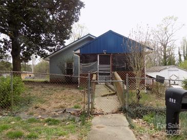 View of the home's exterior, featuring blue siding and an enclosed porch at 526 Peaceful Leaf Ln, Kings Mountain, NC 28086