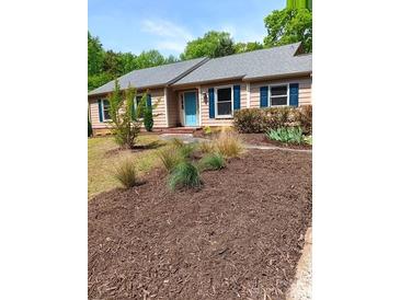 Charming ranch-style home with well-manicured landscaping and a light blue front door at 7412 Broken Oak Ln, Charlotte, NC 28226