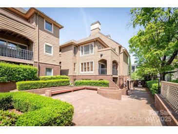 Beautiful multi-level townhome with brick accents, manicured hedges and a spacious brick courtyard at 1101 E Morehead St # 31, Charlotte, NC 28204