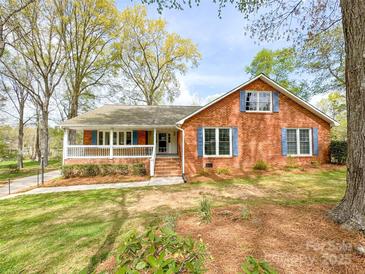 Traditional brick home with a welcoming front porch and eye-catching blue shutters at 12011 Stoney Meadow Dr, Mint Hill, NC 28227