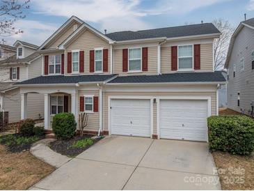 Charming two-story home featuring a two-car garage, red shutters, and well-maintained landscaping at 125 Colville Rd, Mooresville, NC 28117