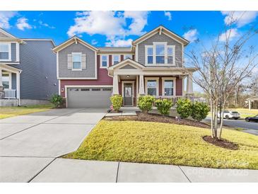 Charming two-story home with a well-manicured lawn, inviting front porch, and neutral-toned color scheme at 12706 Heath Grove Dr, Huntersville, NC 28078