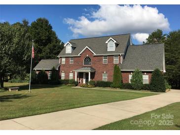 Charming two-story brick home with dormer windows and landscaped front yard at 14124 Hiwassee Rd, Huntersville, NC 28078