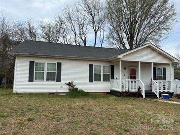 Charming single-story home featuring vinyl siding, a covered porch, and manicured landscaping at 300 S Oakland Ave, Statesville, NC 28677