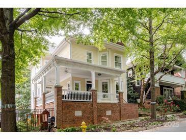 Attractive two-story home featuring a spacious front porch with white railings and a brick foundation at 734 E 10Th St, Charlotte, NC 28202