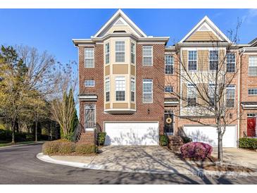 Charming brick townhome featuring a two-car garage, front garden, and inviting entryway for a warm welcome at 7854 Springs Village Ln, Charlotte, NC 28226