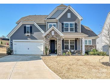 Charming two-story home featuring a stone-accented entryway and well-manicured lawn at 104 Hemlock Cove Ct, Mooresville, NC 28117