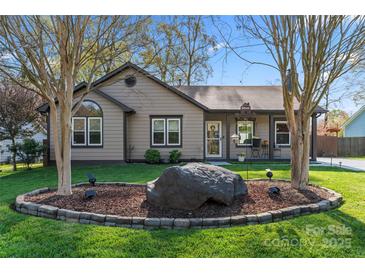Charming home featuring a landscaped front yard with a decorative rock and well-manicured lawn at 14827 Smith Rd, Charlotte, NC 28273