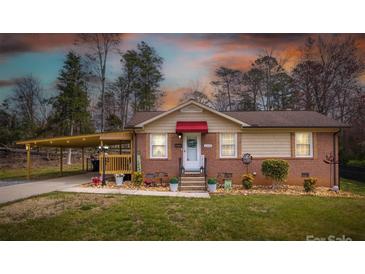 Charming brick home with a red awning, covered carport, and well-manicured lawn at 198 33Rd Nw St, Hickory, NC 28601