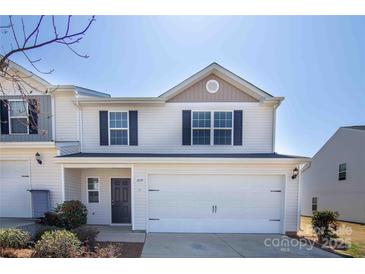 Inviting two-story townhouse with a two-car garage, neutral siding, and well-maintained landscaping at 2035 Talbert Ct, Charlotte, NC 28214