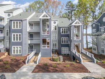 Beautiful condo building with lake view, featuring private balconies and well-maintained landscaping at 329 Northwest Dr, Davidson, NC 28036