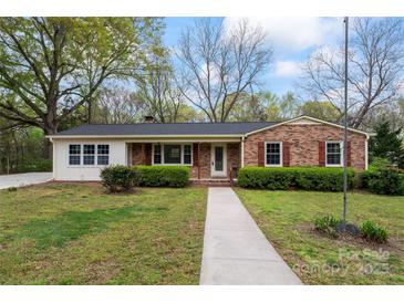 Charming brick home featuring mature trees, manicured shrubs, and a welcoming walkway at 3987 Taxahaw Rd, Lancaster, SC 29720