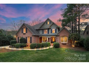 Charming two-story brick home with lush landscaping and inviting entrance at dusk at 8915 Linden Grove Ct, Sherrills Ford, NC 28673