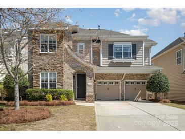 Charming two-story home featuring a stone and siding exterior, two-car garage, and well-maintained landscaping at 9422 Ridgeforest Dr, Charlotte, NC 28277