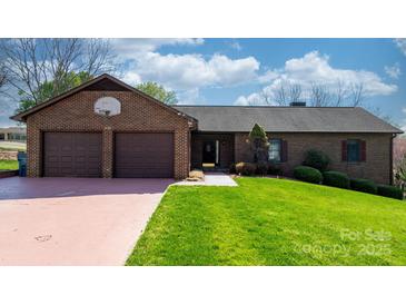 Well-kept brick home with double garage and tidy landscaping, ready for new owners at 3730 Club House Ne Dr, Conover, NC 28613