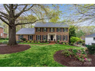 Charming brick two-story home with manicured lawn and mature trees providing great curb appeal at 5125 Winding Brook Rd, Charlotte, NC 28226