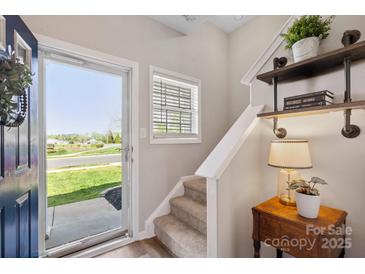 Inviting entryway with natural light and decor, featuring a charming staircase and stylish accents at 5622 Dartington Dr, Indian Land, SC 29707