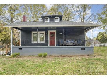 Charming home with a covered front porch and a red front door at 1013 East Dr, Gastonia, NC 28052