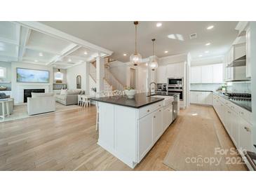A bright, open kitchen featuring a large island, modern appliances, and hardwood floors at 11036 Shreveport Dr, Huntersville, NC 28078