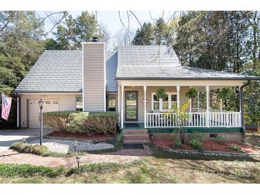 Charming home featuring a cozy front porch and well-maintained landscaping at 11901 Rock Canyon Dr, Charlotte, NC 28226