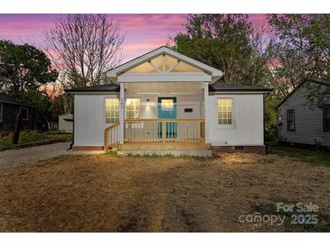 Charming white home featuring a covered front porch with a bright blue front door and a well-manicured lawn at 243 Barber St, Rock Hill, SC 29730