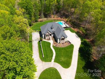 Stunning aerial view showcases circular driveway and lush wooded surroundings at 4071 King Wilkinson Rd, Lincolnton, NC 28092