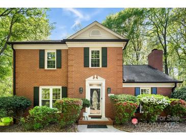 Charming brick home featuring lush landscaping, green shutters, and a classic architectural design at 4522 Woods End Ln, Charlotte, NC 28277