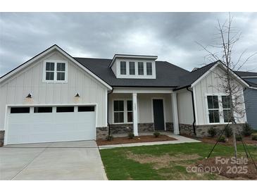 Charming home featuring a light gray exterior, a two-car garage and a welcoming front porch at 5205 Mint Harbor Way # 0353, Charlotte, NC 28269