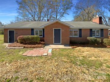 Charming brick home featuring a well-manicured lawn and quaint front porch, with blue shutters at 614 Normandy Rd, Lancaster, SC 29720