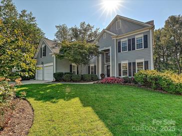 Inviting traditional two-story home with a well-manicured lawn, beautiful landscaping, and a two-car garage at 6325 Hawkwood Ln, Charlotte, NC 28277