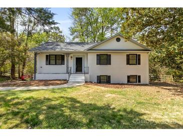 Charming renovated home featuring a classic white painted brick exterior with dark window shutters at 6614 Old Providence Rd, Charlotte, NC 28226