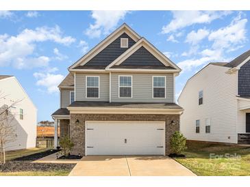 Charming two-story home featuring a brick-accented garage and light gray siding at 7394 Echoing Hills Ln, Maiden, NC 28650