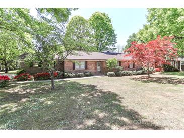 Charming brick home with mature trees and landscaping, creating a welcoming curb appeal at 783 Carpenter Ave, Mooresville, NC 28115