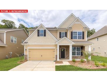Charming two-story home featuring a welcoming front porch, manicured lawn, and attached two-car garage at 116 Fordingbridge Ln, Mooresville, NC 28115