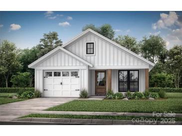 Charming single-story home with white siding, an attached garage, and manicured front lawn at 121 Hamrick Ave, Shelby, NC 28152