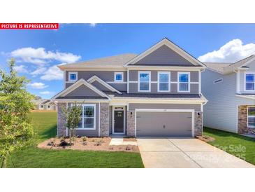 Charming two-story home with gray siding, stone accents, and well-manicured lawn, providing inviting curb appeal at 124 Fordingbridge Ln, Mooresville, NC 28115