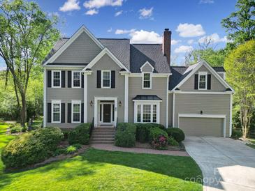 Charming two-story home with a manicured lawn, dark shutters, and brick stairs leading to the front door at 15101 Sharrow Bay Ct # 12, Huntersville, NC 28078