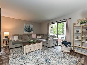 Comfortable living room featuring a large sectional, stylish rug, and sliding glass doors to the outside at 1615 Merry Oaks Rd # G, Charlotte, NC 28205