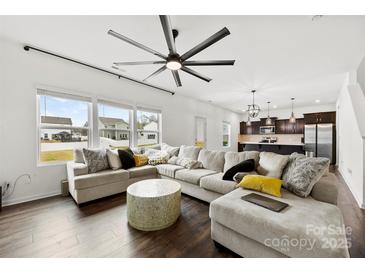 Bright living room with large sectional, modern ceiling fan, and views to the kitchen at 1976 Ethan Ln, Stanfield, NC 28163